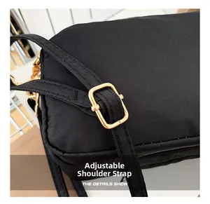 Close-up of the adjustable strap and premium gold metal buckle on a black nylon bag