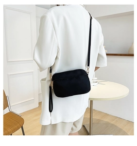 Detailed view of lightweight black nylon crossbody bag with dual zippers and adjustable strap