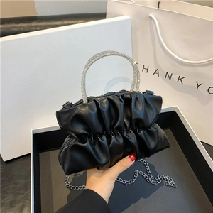 Detail showing soft black ruched leather bag with sparkling rhinestone handle and silver chain