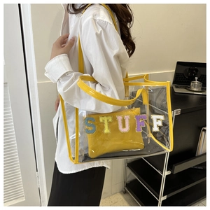 Detail of transparent PVC tote with yellow trim and colorful STUFF towel embroidery
