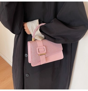 Detail of pink satchel bag with rhinestone flap and gold metal buckle close-up