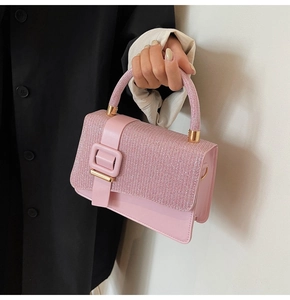 Close-up of pink rhinestone handbag with decorative buckle and sparkling round handle