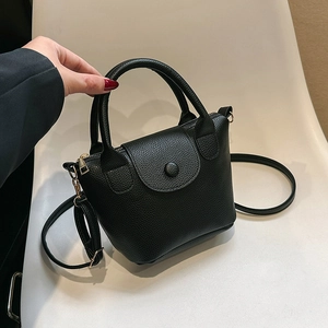 Retro black leather bucket bag with top handle and gold hardware in 45-degree view