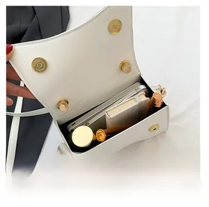 Interior view showing the large capacity of a white leather flap bag for daily essentials
