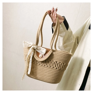 Detailed knit texture of tote bag with white pearl buckle and lace bow decoration