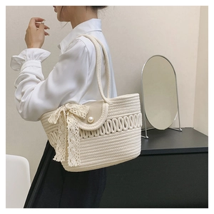 Detail of cotton rope tote bag showing the side lace bow and imitation pearl buckle