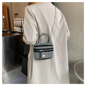 Détail d'un sac à bandoulière étincelant en strass avec chaîne porté par un mannequin