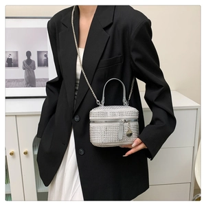 Détail du sac à main argenté avec strass, chaîne métallique et texture de luxe brillante