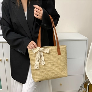 Women straw bucket bag with lace bow and brown leather strap for beach holidays