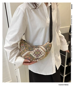 Detailed view of crescent ethnic chest bag with colorful geometric woven patterns