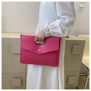 Dettaglio borsa tote rosa acceso con trama coccodrillo, chiusura in metallo e manico
