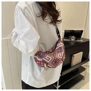Detail of colorful geometric knit tote bag with adjustable shoulder strap and crescent shape