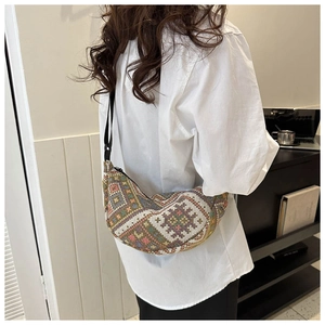 Detail of bohemian crescent tote bag with colorful geometric woven fabric and black strap