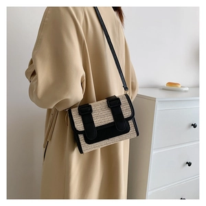 Détail d'un sac bandoulière en paille tressée avec garniture en cuir noir sur mannequin