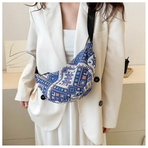 Blue and white jacquard woven crescent bag with adjustable black strap and geometric pattern