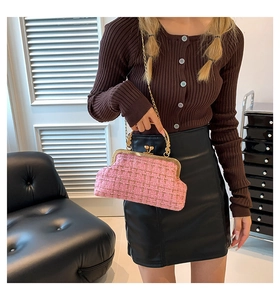 Detail of pink tweed bag with vintage gold clasp and textured metal handle design