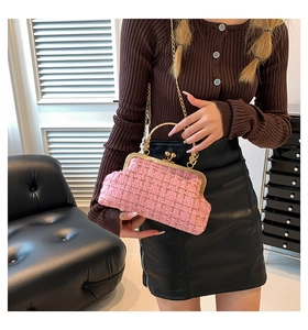 Pink tweed crossbody handbag with gold clasp and metal handle on a leather chair