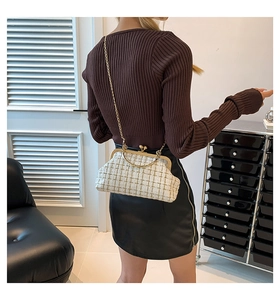 Detail of white tweed crossbody bag with gold chain strap worn by a female model