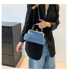 Detail of blue tweed vintage handbag with gold frame and elegant beaded handle on model