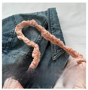 Détail du sac à bandoulière matelassé rose avec une poignée froncée élégante