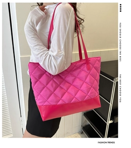 Side view of large quilted pink tote bag made of glossy nylon with leather base contrast