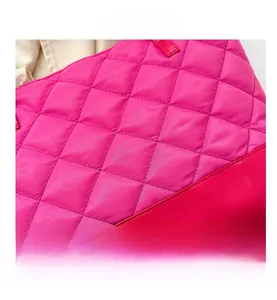 Detailed macro of hot pink quilted nylon tote bag showing texture and leather base