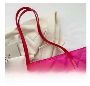 Close-up of fuchsia quilted tote bag with detailed stitching and water-resistant nylon fabric
