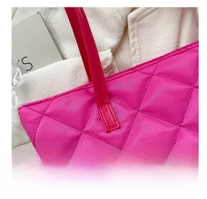 Close-up of diamond quilted texture and handle stitching on a bright pink tote bag