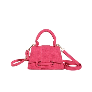Mini rose pink woven embossed handbag with top handle and gold hardware on white background