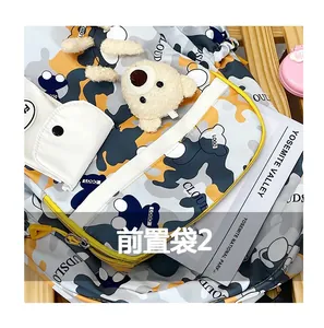 Detailed view of camouflage backpack with plush bear and yellow zipper compartment