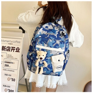 Detail view of floral camouflage backpack with multiple compartments and cute bear pendant