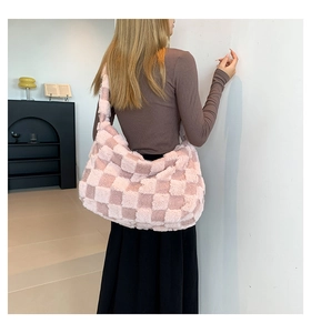 Detail of pink checkerboard plush hobo bag showing soft fluffy texture and wide strap