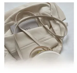 Detail of quilted leather texture and adjustable shoulder strap on the round crossbody bag