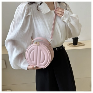 Pink round leather crossbody bag with embossed logo detail and gold-tone zippers
