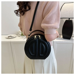 Detail of black semi-circular crossbody bag with DD quilting and gold dual zippers