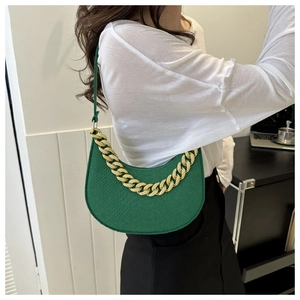 Detail view of the deep green crocodile-pattern crescent bag with a decorative gold chain