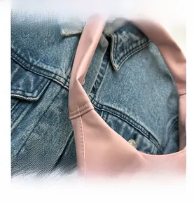Detail shot of pink crossbody bag showing fine stitching and soft leather texture