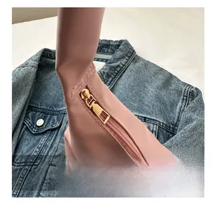 Detail view of smooth golden zipper and pink faux leather on a casual shoulder bag