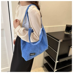 Gros plan sur un sac cabas en velours côtelé bleu avec étiquette textile FASHION