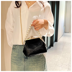 Détail du sac bandoulière noir plissé avec poignée en perles et chaîne en métal