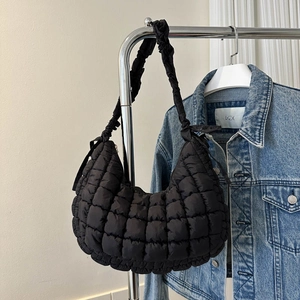 Détail du sac nuage noir matelassé en nylon avec des bretelles plissées et des nœuds