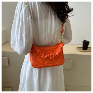 Detail der leuchtend orangefarbenen Falten-Tote mit geometrischer Steppung und Goldbeschlag