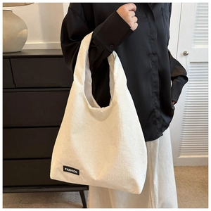 Détail du sac cabas en velours côtelé blanc cassé montrant la texture et l'étiquette