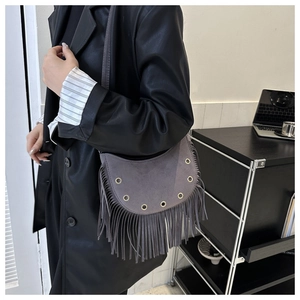Détail du sac à franges en daim gris avec anneaux dorés et style bohème moderne