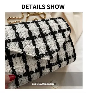 Primer plano del bolso bandolera de tweed blanco y negro con cadena dorada fina
