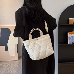 Modern white quilted tote bag with lattice pattern and wide strap shown on model back