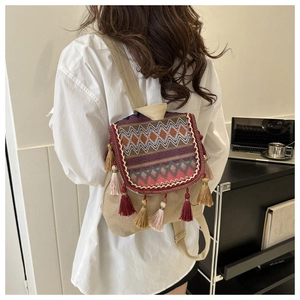 Detail of bohemian backpack showing ethnic geometric embroidery and colorful tassels