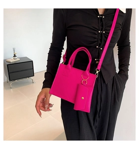 Detail of rose red quilted crossbody bag with small detachable pouch and shoulder strap