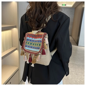 Detail of bohemian backpack with colorful woven patterns and handmade fringe tassels