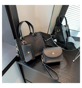 Close-up of black quilted leather handbags with gold metal hardware on mirrored surface